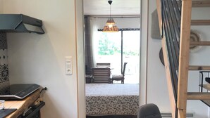 A kitchen with wooden flooring, a dining area with a table and chairs, and a staircase.