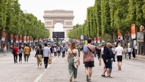 Une rue animée avec l’Arc de Triomphe en arrière-plan.