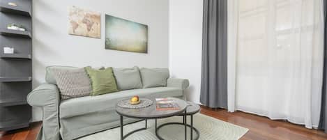 Un salon moderne avec un canapé gris, une table basse et une bibliothèque.