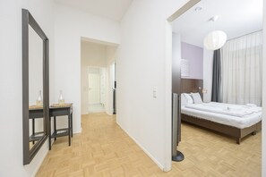 Una habitación de hotel con cama, mesita de noche y espejo.