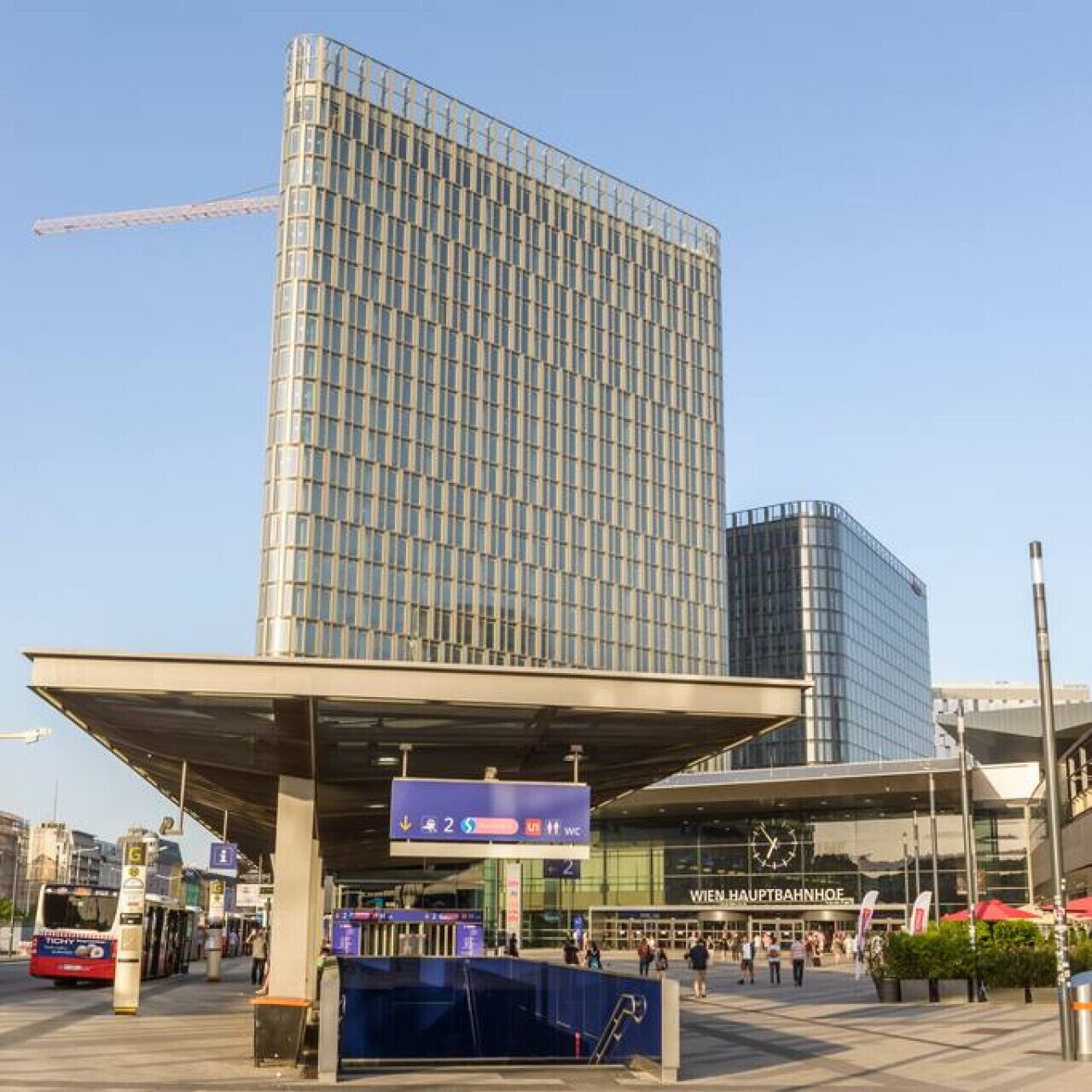 Um edifício moderno com fachada de vidro e área de entrada coberta.