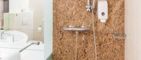 A modern bathroom with a granite shower wall, a handheld showerhead, and a built-in soap dispenser.