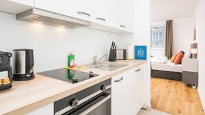 Una cocina moderna con estufa integrada, hervidor y lavabo. Hay un letrero azul con la palabra 