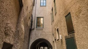 Une ruelle étroite, située entre deux bâtiments dotés de nombreuses fenêtres et d’une arche centrale.
