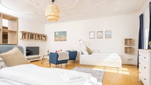 Une chambre moderne comprenant un lit, un bureau, une chaise, un canapé et un téléviseur.
