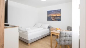 Une chambre moderne avec un lit, une table de chevet et un bureau avec une chaise.