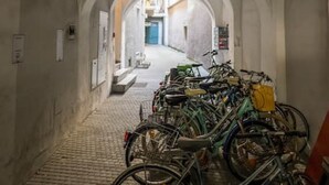 Um corredor em arco com bicicletas estacionadas no final.