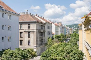 A row of historic buildings with classical architecture, including a prominent building with a central entrance and columns. - Ottakring Balcony Suite (Vienna)