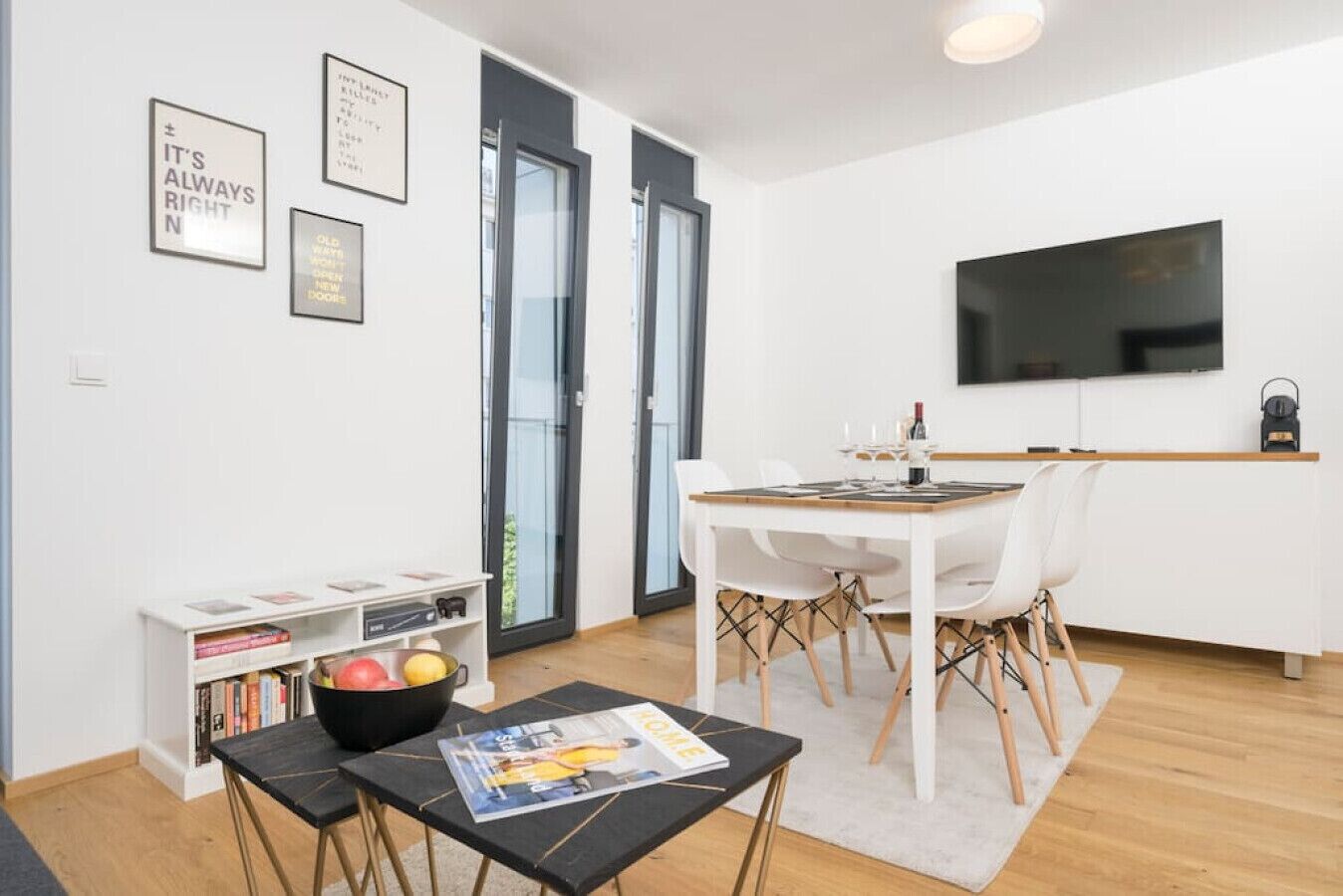 Un soggiorno moderno con angolo pranzo, TV a schermo piatto e libreria.