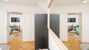 A modern interior with a wooden ceiling, a black partition, and a dining area with a table and chairs. - Zum Grazer Uhrturm in Graz Austria (Graz)