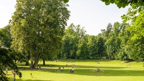 A park with open grassy areas, trees, and people relaxing. - Zum Grazer Uhrturm in Graz Austria (Graz)