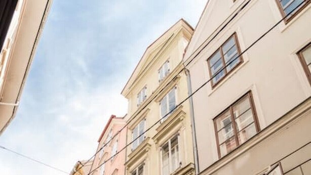 Straßenansicht mit Gebäuden, darunter ein Geschäft mit der Aufschrift 'tik tak'.