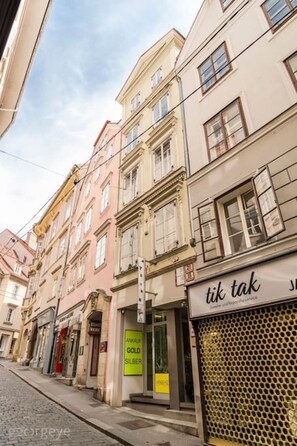 A street view with buildings, including a shop with a sign that reads "tik tak".