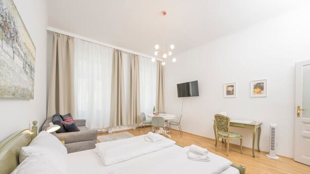 A hotel room with two beds, a desk, a chair, a TV, and a large window with curtains. - Best of Hernals Top 24 (Vienna)