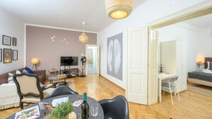 A spacious living area with a dining table, chairs, and a TV in the background.