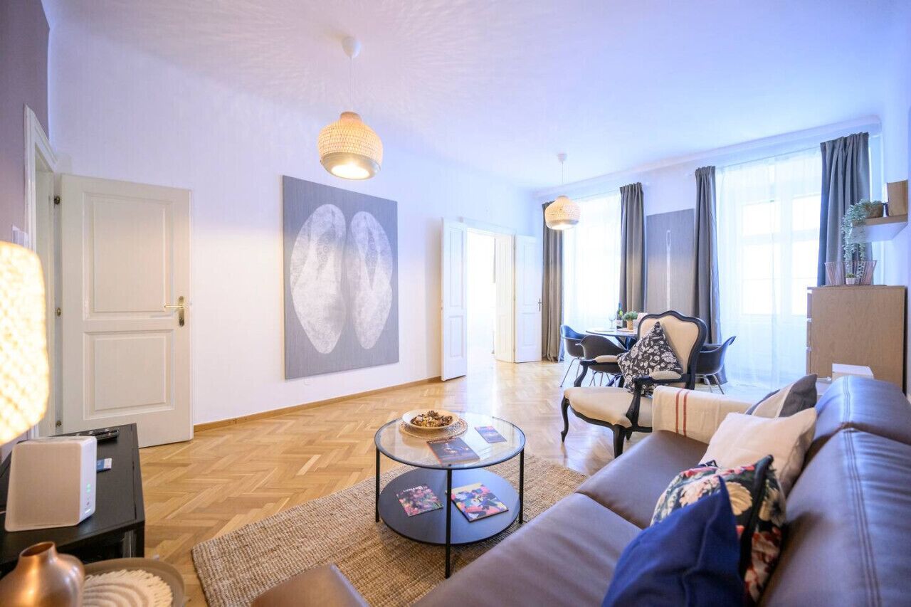 Een moderne woonkamer met een bank, salontafel en kunstwerk aan de muur.