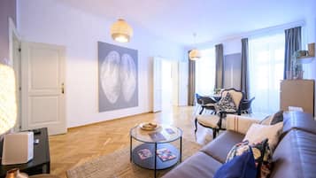 Een moderne woonkamer met een bank, salontafel en kunstwerk aan de muur.