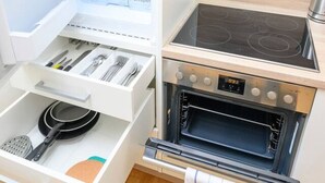 Une cuisine compacte équipée d’un réfrigérateur intégré, d’une cuisinière et d’un four.