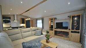 Un salon moderne avec un canapé beige, une table basse en bois et un téléviseur à écran plat.