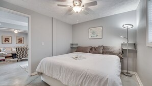 A bedroom with a large bed, a ceiling fan, a bedside table with a lamp, and a framed picture on the wall. - Missouri Couple's Retreat: 'shouse' w/ Patio, Yard (Nixa)