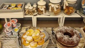 A buffet table with various food items including yogurt, pastries, and a bundt cake. - Ro agrimaison  (Volla)