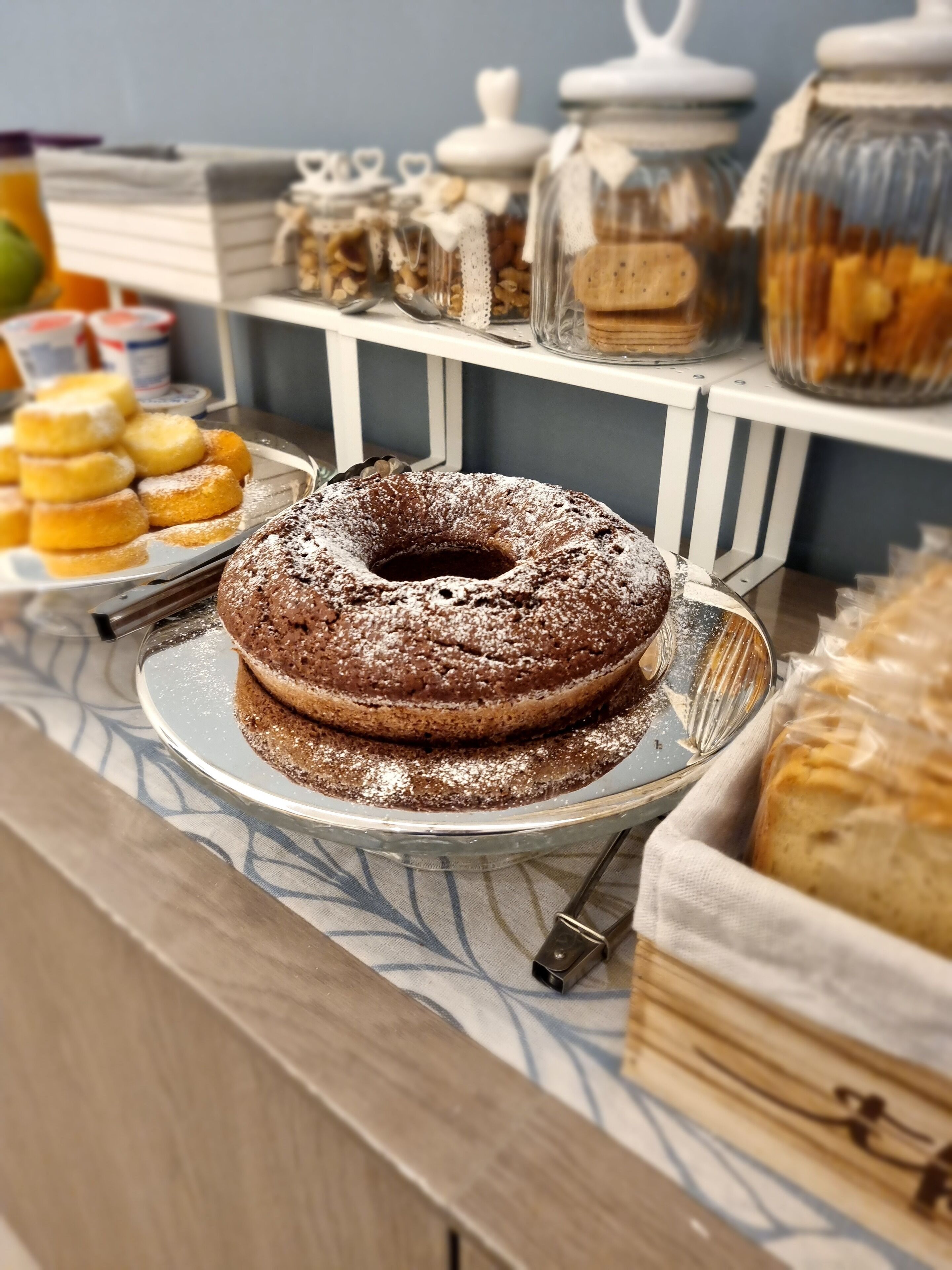 Un buffet proposant un gâteau Bundt au chocolat, des beignets et diverses pâtisseries.