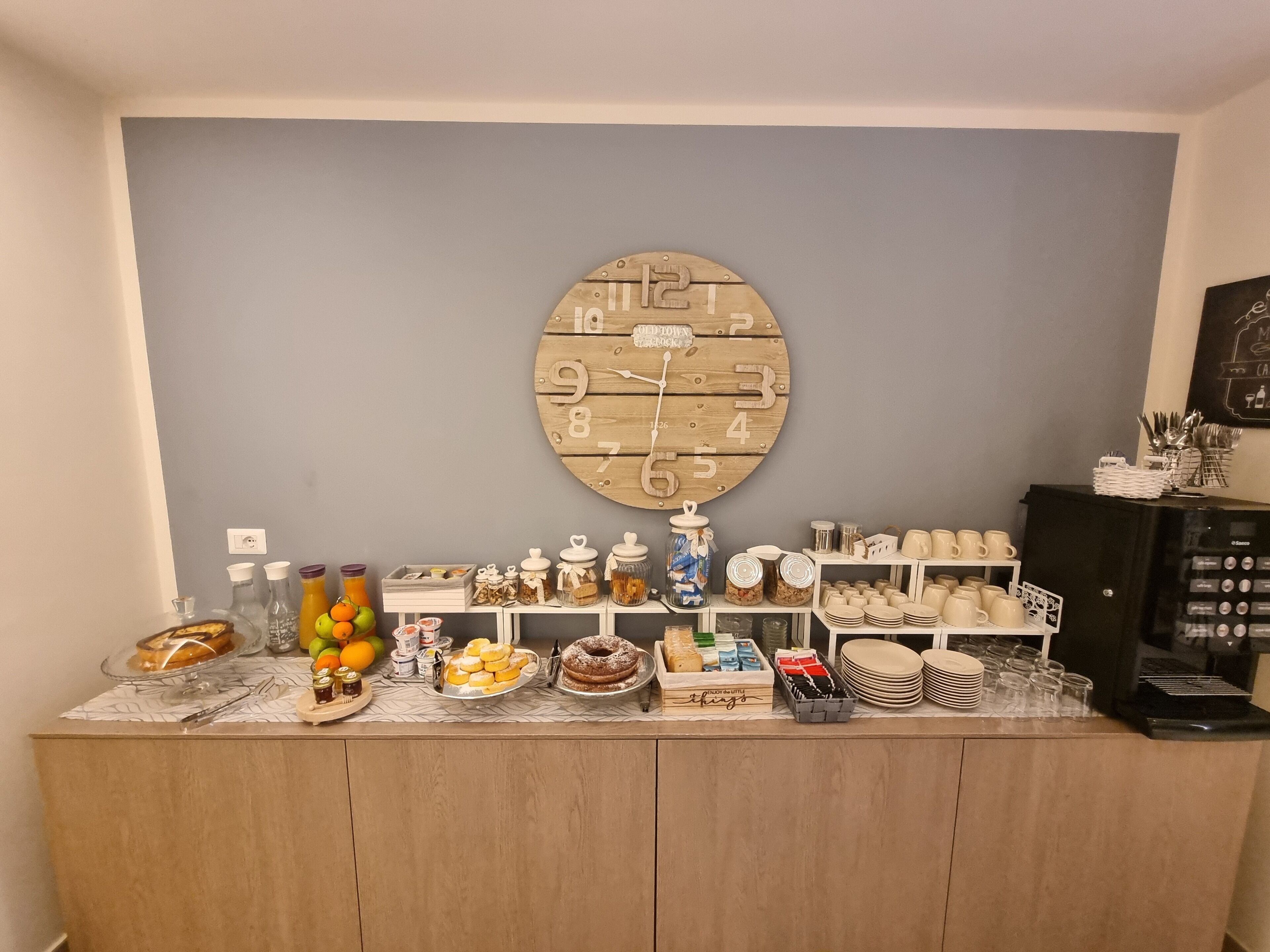 A breakfast bar with various food items and a clock on the wall.