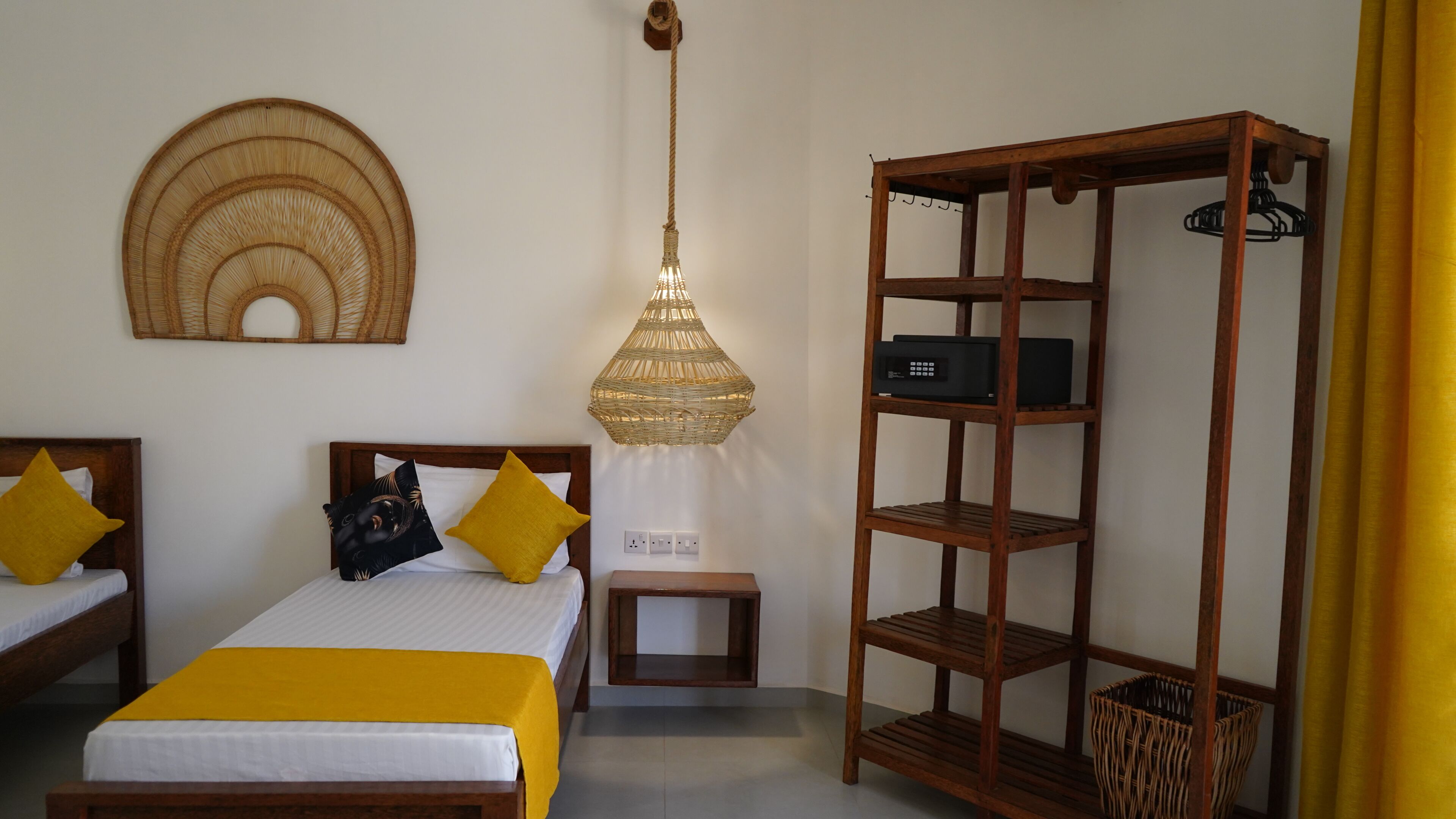 Una camera da letto con due letti, un lampadario, una libreria in legno e un elemento decorativo a parete.