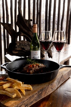 Un repas avec une bouteille de vin et des verres sur une table en bois.