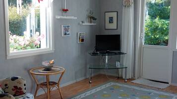 A living room with a television, a dining table, and a sofa.