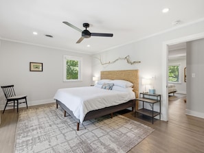 A bedroom with a bed, a ceiling fan, a nightstand, a chair, a window, and a wall-mounted branch decoration. - Minutes from Downtown St. Michaels | Pool | Hot Tub (Bozman)