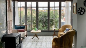 A cozy room with a large window, a wooden ceiling, and a rustic aesthetic. - Cosy Little House &garden (Arcachon)
