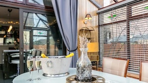 A table with a champagne bucket, a decorative vase, and a glass of champagne.