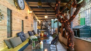 A cozy indoor seating area with wooden walls, a round table, and a large clock.