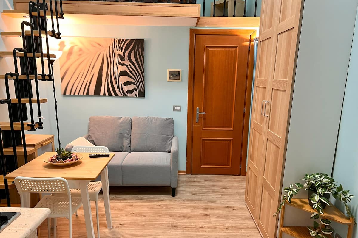 A compact living space with a sofa, a dining table, and a wooden cabinet.