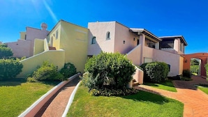A residential building with a paved driveway and a well-maintained lawn.