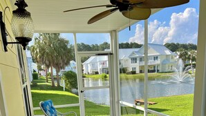 A covered patio with wicker furniture, a ceiling fan, and a view of a lake and houses. - 197 Georges Bay Road (Margonitaville) (Surfside Beach)