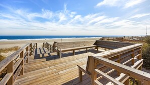 A wooden boardwalk leading to a beach with benches and railings. - Beach Nuts - Oceanfront, 4-bedrooms (Pawleys Island)