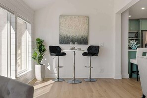 Uma cozinha moderna com área de refeições, incluindo dois bancos altos e uma mesa com copos.
