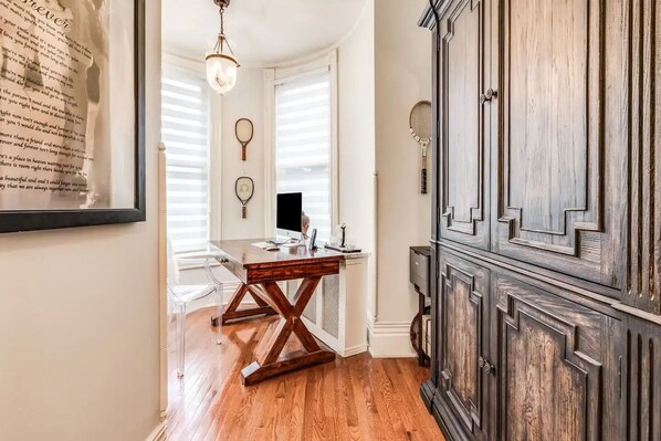 A room with a wooden desk, a computer, and a cabinet.