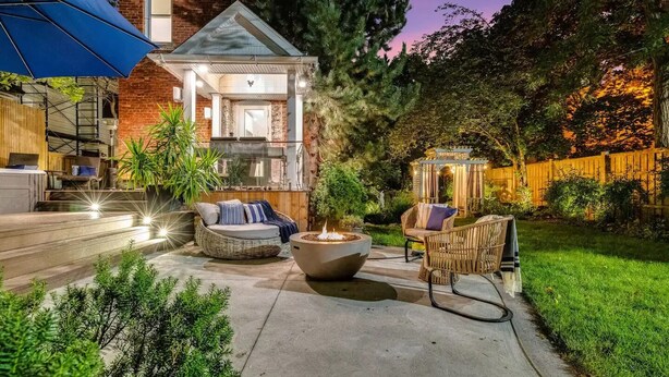 A patio area with outdoor seating, a fire pit, and a pergola. - The Victorian on Victoria (Windsor)