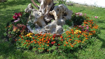 A garden with a central rock formation surrounded by colorful flowers.
