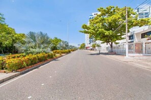 Stroll along this scenic street lined with lush greenery and modern buildings.