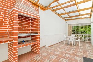 Enjoy al fresco dining and socializing in this patio area with a barbecue grill and dining table.