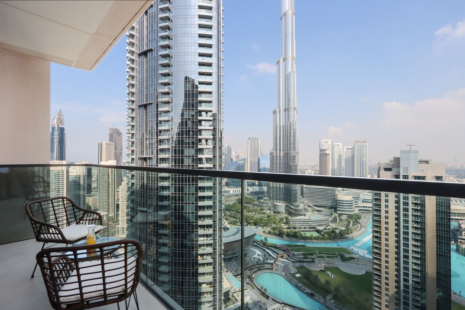 A balcony with a view of a modern cityscape, including high-rise buildings and a marina.