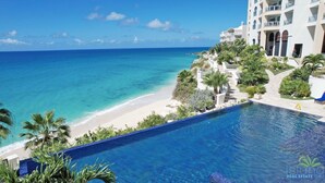 A resort pool with a view of the beach and ocean. - ☀️🌴Dreams Come True by IRE Vacations - Luxury 5 bedrooms Condo by the Beach (Cupecoy)