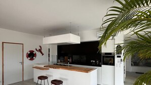 Une cuisine moderne dotée d’un îlot central, de tabourets de bar et d’un élément décoratif mural.