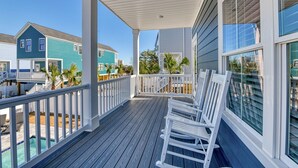 A covered porch with a pool, white railings, and a view of neighboring houses. - Luxurious 5 Bedroom, 5.5 Bath with Private Pool & Elevator (Garden City Beach)