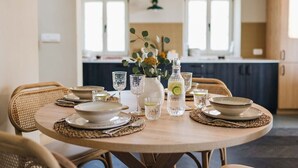 A dining table set with plates, glasses, and a vase with flowers. - Casa Amalia with saltwater pool (Visnjan)