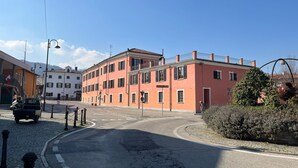A street with buildings, a clear sky, and a parked vehicle. - Dimora San Secondo (San Secondo di Pinerolo)